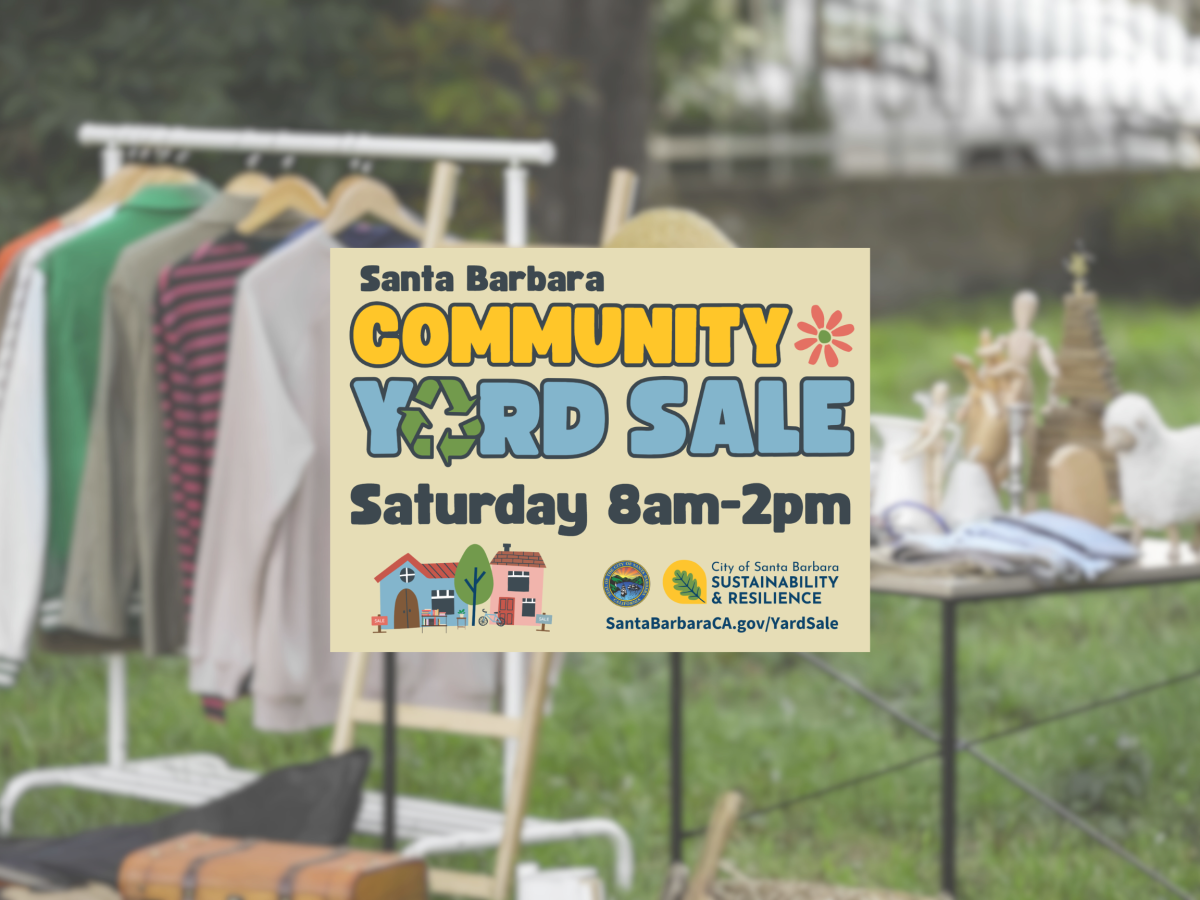 Photo of a yard sale with clothing and other items on a table 
